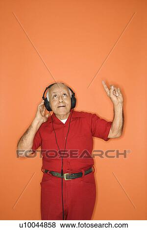 Stock Photo - Mature adult Caucasian male listening to headphones.. Fotosearch