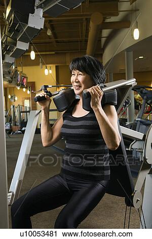 Mature Asian adult female using exercise machine at gym. View Large Photo Image Stock Image - Mature Asian adult female using exercise machine at gym.. Fotosearch