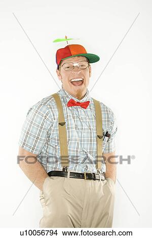 Caucasian young man dressed like nerd wearing propeller cap with hands in pockets looking at viewer with big smile. View Large Photo Image Picture - Caucasian young man dressed like nerd wearing propeller cap with hands in pockets looking at viewer with big smile.. Fotosearch