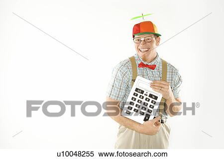Caucasian young man dressed like nerd wearing beanie and smiling while holding large calculator. View Large Photo Image Stock Photography - Caucasian young man dressed like nerd wearing beanie and smiling while holding large calculator.. Fotosearch