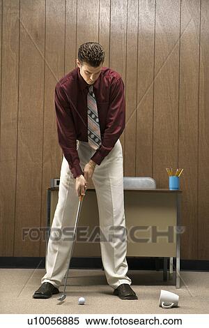 Caucasion mid-adult retro businessman putting golf ball into coffee cup in his office. View Large Photo Image Stock Photography - Caucasion mid-adult retro businessman putting golf ball into coffee cup in his office.. Fotosearch