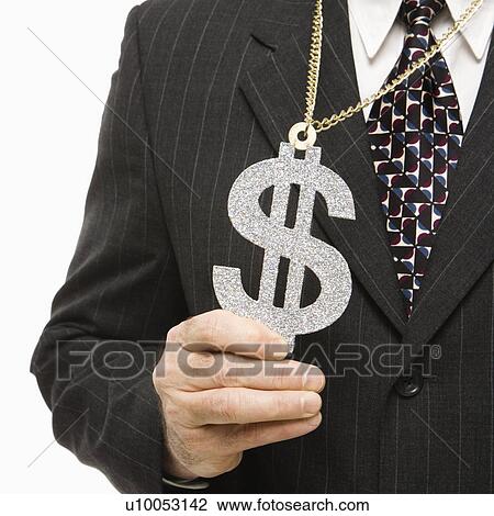 Stock Image - Close-up of Caucasian middle-aged businessman wearing chain necklace with oversized dollar sign.. Fotosearch