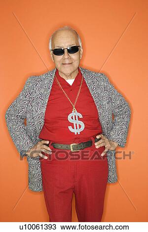 Stock Image - Mature adult Caucasian male wearing money sign necklace.. Fotosearch
