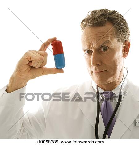 Mid-adult Caucasian male doctor holding an oversized medical pill. View Large Photo Image Stock Photo - Mid-adult Caucasian male doctor holding an oversized medical pill.. Fotosearch