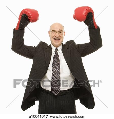 Smiling Caucasian middle-aged businessman standing with arms raised wearing boxing gloves. View Large Photo Image Stock Photo - Smiling Caucasian middle-aged businessman standing with arms raised wearing boxing gloves.. Fotosearch