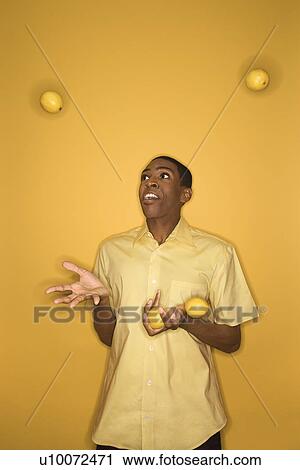Young African-American man juggling lemons on yellow background. View Large Photo Image Stock Image - Young African-American man juggling lemons on yellow background.. Fotosearch