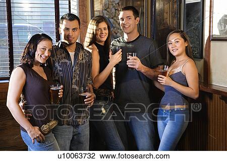 Group of young friends hanging out in pub and drinking beer. View Large Photo Image Stock Image - Group of young friends hanging out in pub and drinking beer.. Fotosearch