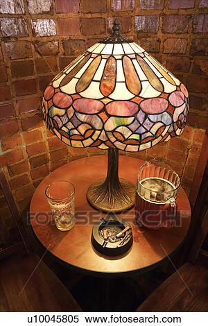 High angle still life of table with beer glass, pitcher, and cigarette ashtray in nightclub. View Large Photo Image Stock Photography - High angle still life of table with beer glass, pitcher, and cigarette ashtray in nightclub.. Fotosearch