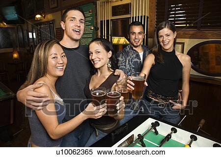 Portrait of group of young friends hanging out in pub and drinking beer. View Large Photo Image Stock Photography - Portrait of group of young friends hanging out in pub and drinking beer.. Fotosearch