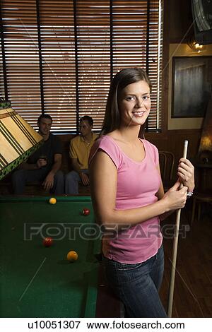 Portrait of woman standing by billiards table holding pool stick. View Large Photo Image Stock Photo - Portrait of woman standing by billiards table holding pool stick.. Fotosearch
