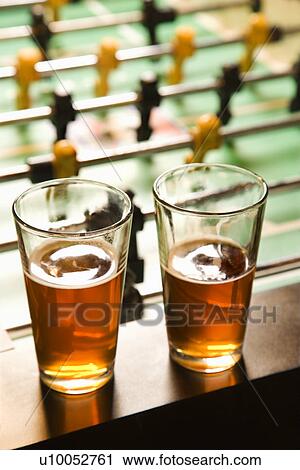 Two glasses of beer on foosball table. View Large Photo Image Stock Image - Two glasses of beer on foosball table.. Fotosearch