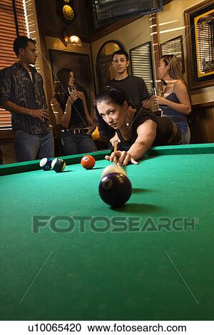 Young caucasian woman preparing to hit pool ball while playing billiards. View Large Photo Image Stock Image - Young caucasian woman preparing to hit pool ball while playing billiards.. Fotosearch