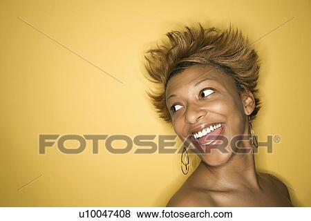 Portrait of smiling African-American young adult woman on yellow background. View Large Photo Image Stock Photo - Portrait of smiling African-American young adult woman on yellow background.. Fotosearch