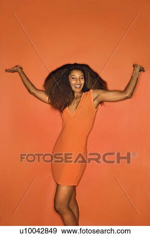 Portrait of smiling sexy young African-American adult woman with big hair on orange background wearing dress. View Large Photo Image Stock Photo - Portrait of smiling sexy young African-American adult woman with big hair on orange background wearing dress.. Fotosearch