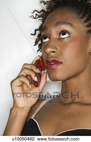 Young sexy African-American woman holding cellphone to ear and rolling eyes upward. View Large Photo Image Stock Image - Young sexy African-American woman holding cellphone to ear and rolling eyes upward.. Fotosearch