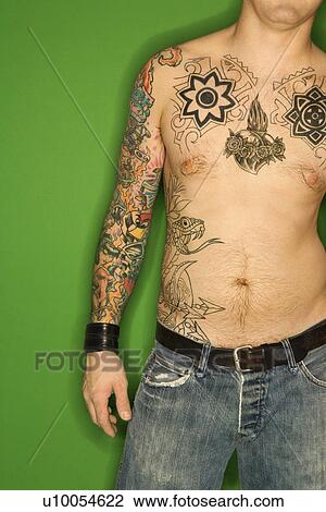 Bare torso of Caucasian man with tattoos standing against green background. View Large Photo Image Stock Image - Bare torso of Caucasian man with tattoos standing against green background.. Fotosearch