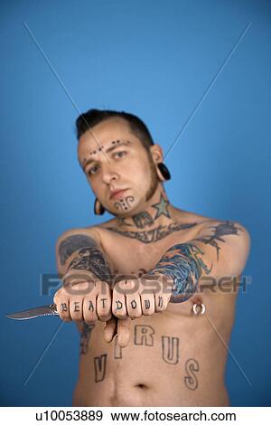 Barechested Caucasian mid-adult man with tattoos and piercings holding knife. View Large Photo Image Stock Photo - Barechested Caucasian mid-adult man with tattoos and piercings holding knife.. Fotosearch