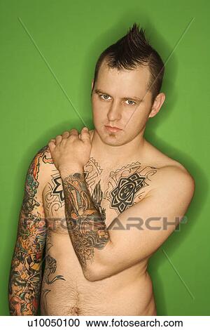 Caucasian man with mohawk and tattoos standing against green background. View Large Photo Image Stock Image - Caucasian man with mohawk and tattoos standing against green background.. Fotosearch