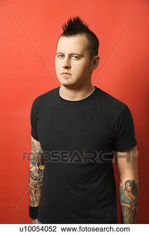Caucasian man with mohawk and tattoos standing against orange background. View Large Photo Image Stock Image - Caucasian man with mohawk and tattoos standing against orange background.. Fotosearch