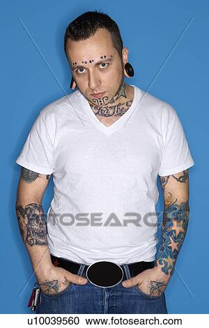 Stock Image - Caucasian mid-adult man with tattoos and piercings.. Fotosearch