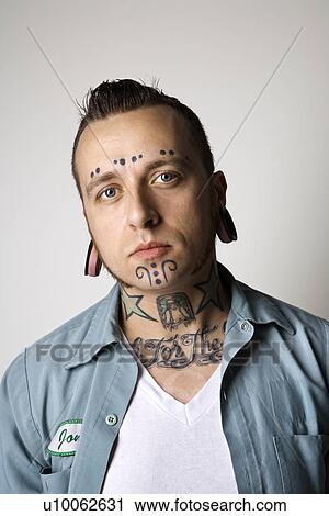 Stock Image - Caucasian mid-adult man with tattoos and piercings.. Fotosearch