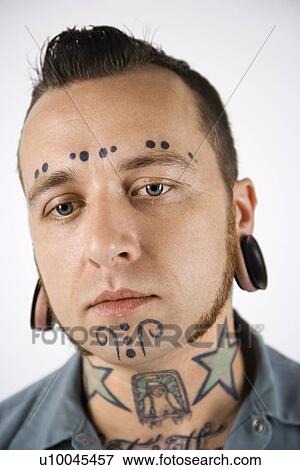 Stock Photo - Caucasian mid-adult man with tattoos and piercings.. Fotosearch
