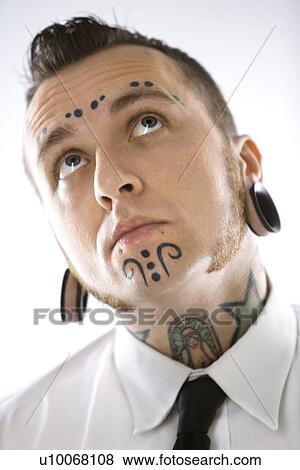 Stock Photo - Caucasian mid-adult man with tattoos and piercings.. Fotosearch