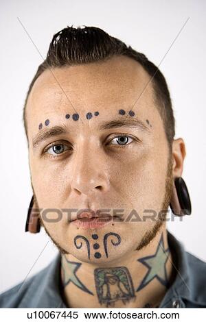 Stock Photography - Caucasian mid-adult man with tattoos and piercings.. Fotosearch