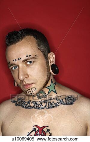 Stock Photography - Caucasian mid-adult man with tattoos and piercings.. Fotosearch