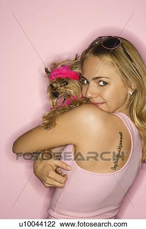 Stock Image - Caucasian young adult female holding Yorkshire Terrier dog.. Fotosearch