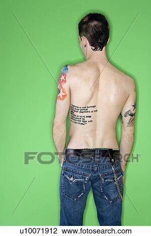 Stock Image - Rear view of tattooed young adult Caucasian male.. Fotosearch