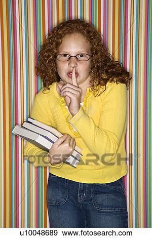 Caucasian female child holding books and holding finger to lips. View Large Photo Image Stock Photo - Caucasian female child holding books and holding finger to lips.. Fotosearch