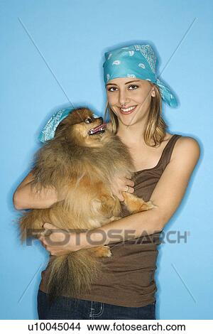Picture - Caucasian teen female holding Pomeranian dog.. Fotosearch