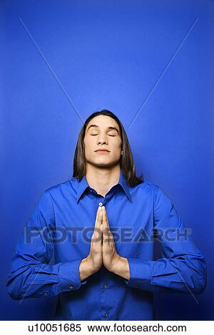 Portrait of Asian-American teen boy with palms pressed together in prayer position standing against blue background. View Large Photo Image Stock Photography - Portrait of Asian-American teen boy with palms pressed together in prayer position standing against blue background.. Fotosearch