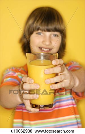 Portrait of Caucasian boy holding out glass of orange juice. View Large Photo Image Stock Photo - Portrait of Caucasian boy holding out glass of orange juice.. Fotosearch