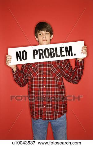 Stock Photo - Portrait of Caucasian teen boy holding no problem sign under his chin.. Fotosearch