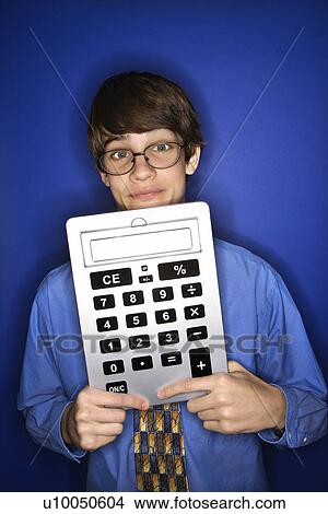 Portrait of Caucasian teen boy wearing eyeglasses and necktie holding oversized calculator. View Large Photo Image Picture - Portrait of Caucasian teen boy wearing eyeglasses and necktie holding oversized calculator.. Fotosearch