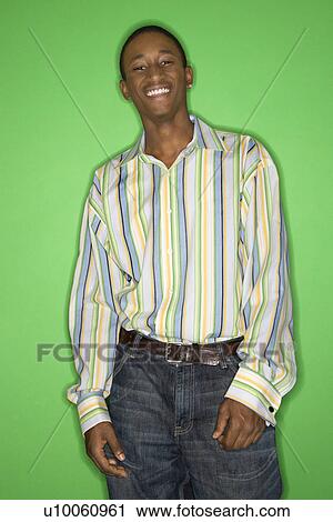 Portrait of smiling African-American teen boy standing in front of green background. View Large Photo Image Stock Image - Portrait of smiling African-American teen boy standing in front of green background.. Fotosearch