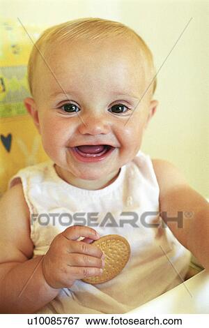 Stock Photo - Baby eating biscuit. Fotosearch