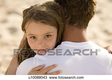 Stock Image - Daughter and father on beach. Fotosearch