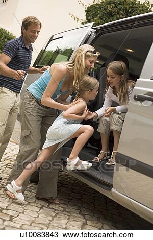 Stock Image - Family getting into car. Fotosearch