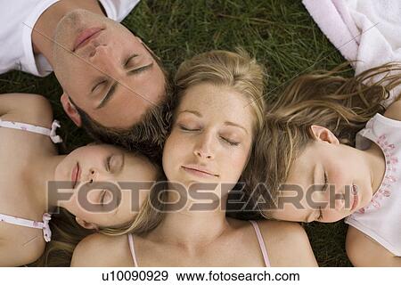 Stock Photo - Family lying on grass. Fotosearch