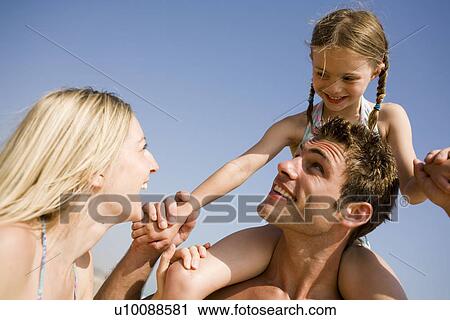 Stock Image - Family on beach playing together. Fotosearch