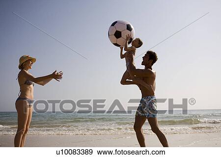 Stock Photo - Family on beach playing together. Fotosearch