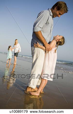 Stock Photo - Family playing on beach. Fotosearch