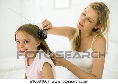 Stock Photo - Mother and daughter, brushing hair. Fotosearch