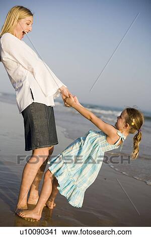 Stock Image - Mother and daughter on beach. Fotosearch