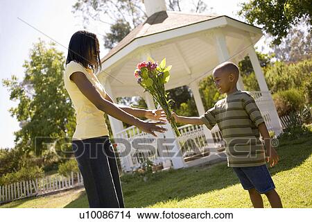 Picture - Young boy and mother with flowers. Fotosearch