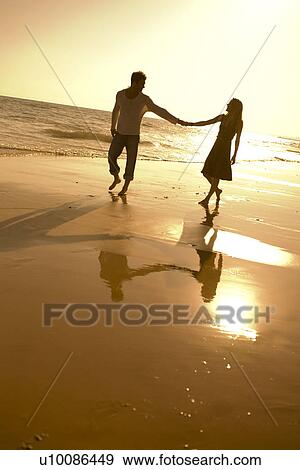 Stock Photo - Couple walking on beach . Fotosearch