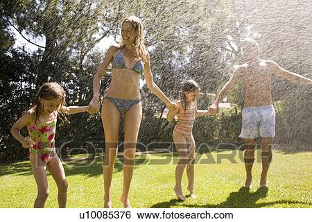 Stock Photograph - Family at home playing in garden. Fotosearch